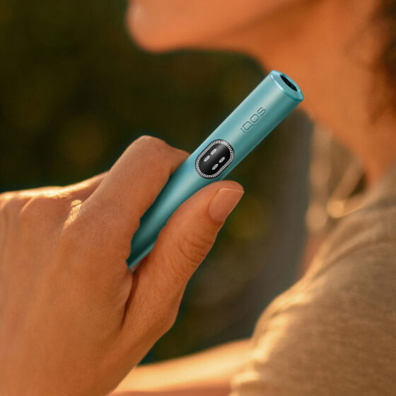 A moss green IQOS ILUMA Holder inside a Pocket Charger.