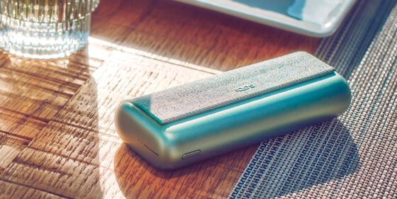Green IQOS ILUMA PRIME Pocket Charger on a table.