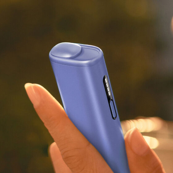A charging cable being inserted into an IQOS ILUMA Holder.