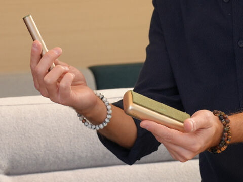 Hands holding smartphones and one IQOS device.
