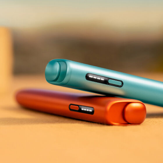 A moss green IQOS ILUMA Holder inside a Pocket Charger.