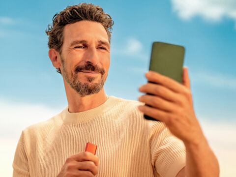 Hands holding an unopened IQOS device box.