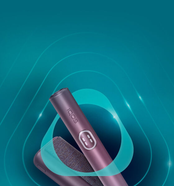 Promotional banner for IQOS ILUMA Prime featuring a sleek black device and charging case on a turquoise background. The text announces a new reduced price of 28 KWD, down from the original 35 KWD, with a note about the recommended retail price.