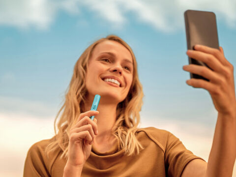 Hands holding an unopened IQOS device box.