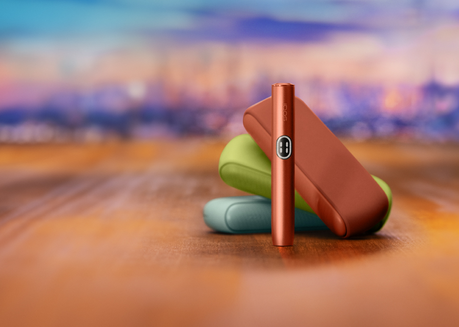 A jade green IQOS ILUMA device and charger.