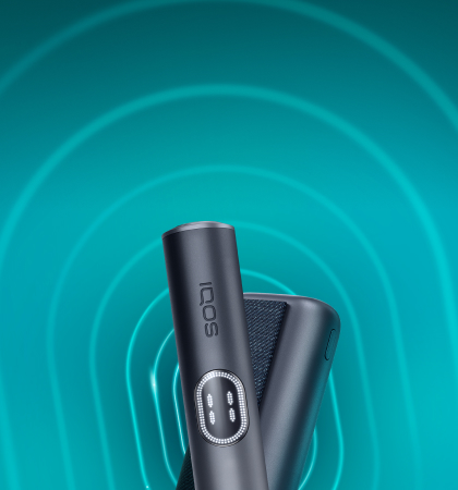 Close up of a chef's hands opening a jade green IQOS ILUMA device.